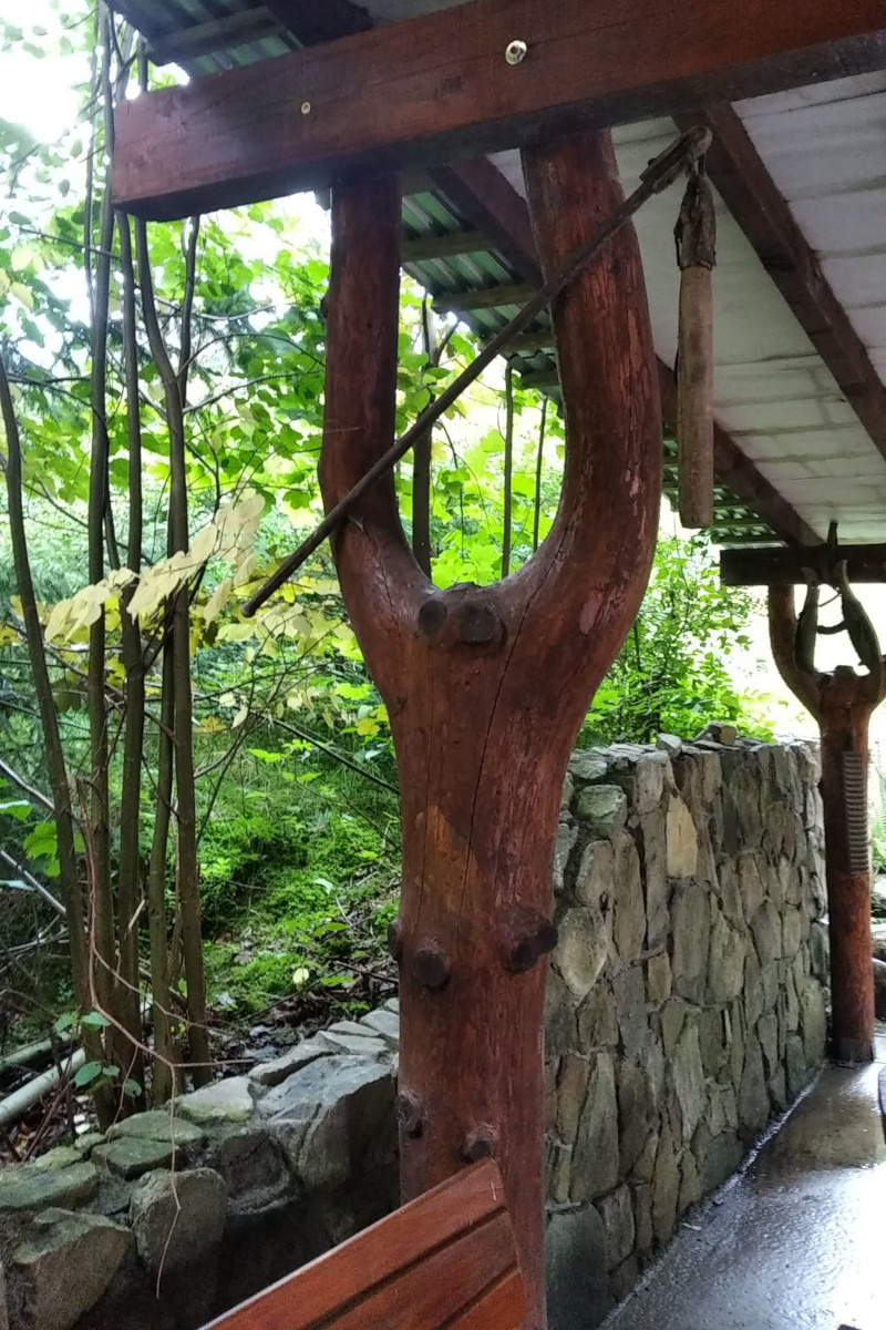 Podpora dachu z zachowanym kształtem pnia, u szczytu zawieszony cep - dawne narzędzie rolnicze do młócenia zboża